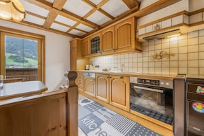 A kitchen with wooden cabinets, a built-in oven, and a window overlooking a scenic landscape.