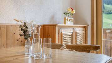 Een houten tafel met heldere glazen flessen en een vaas met gedroogde planten.