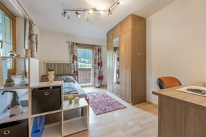 Un dormitorio moderno con cama, escritorio, armario y radiador.