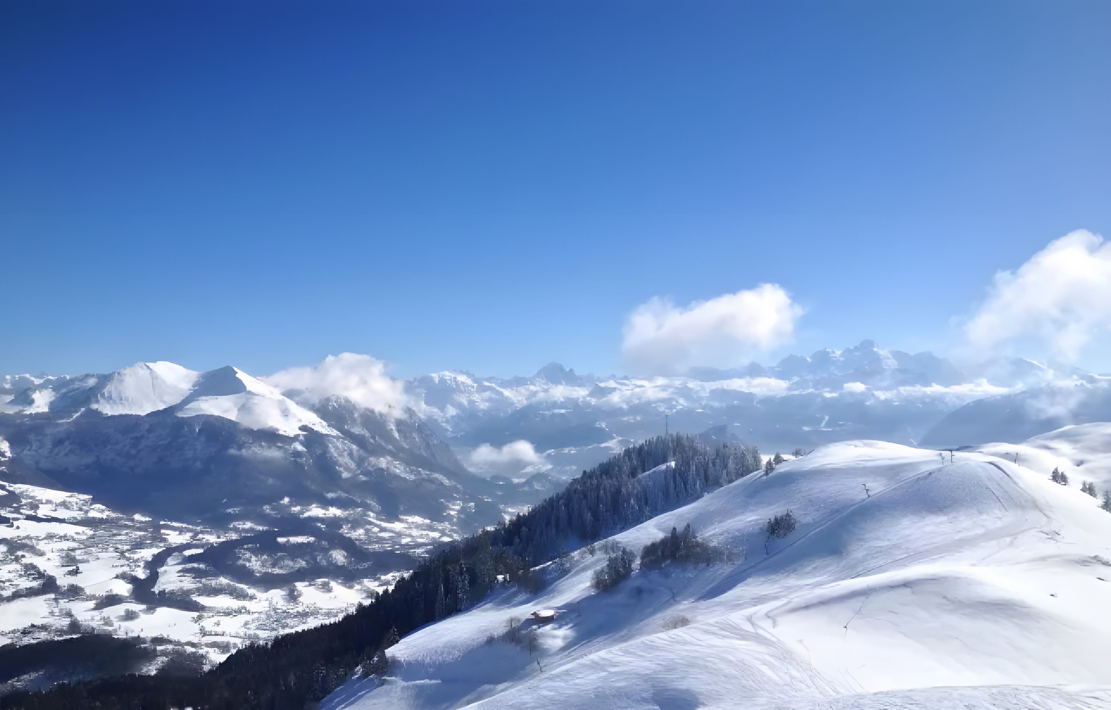 Un paysage montagneux enneigé sous un ciel dégagé.
