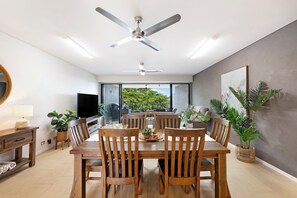 A dining area with a table, chairs, and a ceiling fan. - Lagoon Glow Waterfront Sunsets and Poolside Days (Darwin)