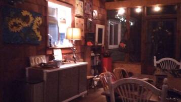 A wooden interior with a dining area, a bar, and a ceiling fan.