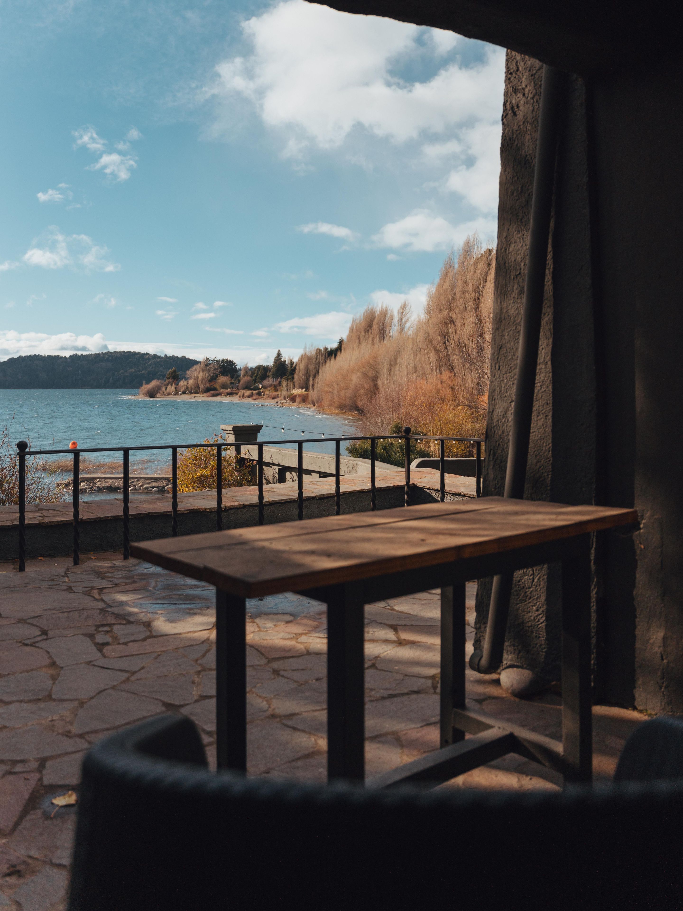 Un espace extérieur aménagé avec des sièges, offrant une vue sur un lac et des arbres.