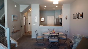 A dining area with a table and chairs, a kitchen in the background, and a staircase leading to another level. - Fantastic 2-bedroom townhome in sunny Fort Myers with private back yard. (Fort Myers)