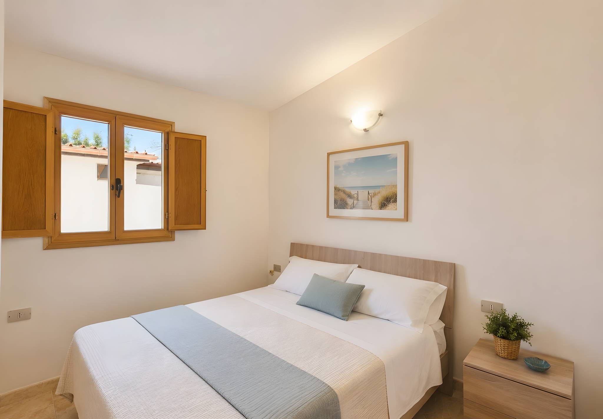 Ein Schlafzimmer mit einem Bett, einem Nachttisch, einem Wandbild und einem Fenster mit Holzjalousien.