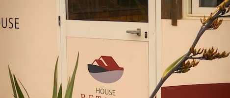 A building entrance with a sign reading 'HOUSE BETANIA' and a door with a handle.