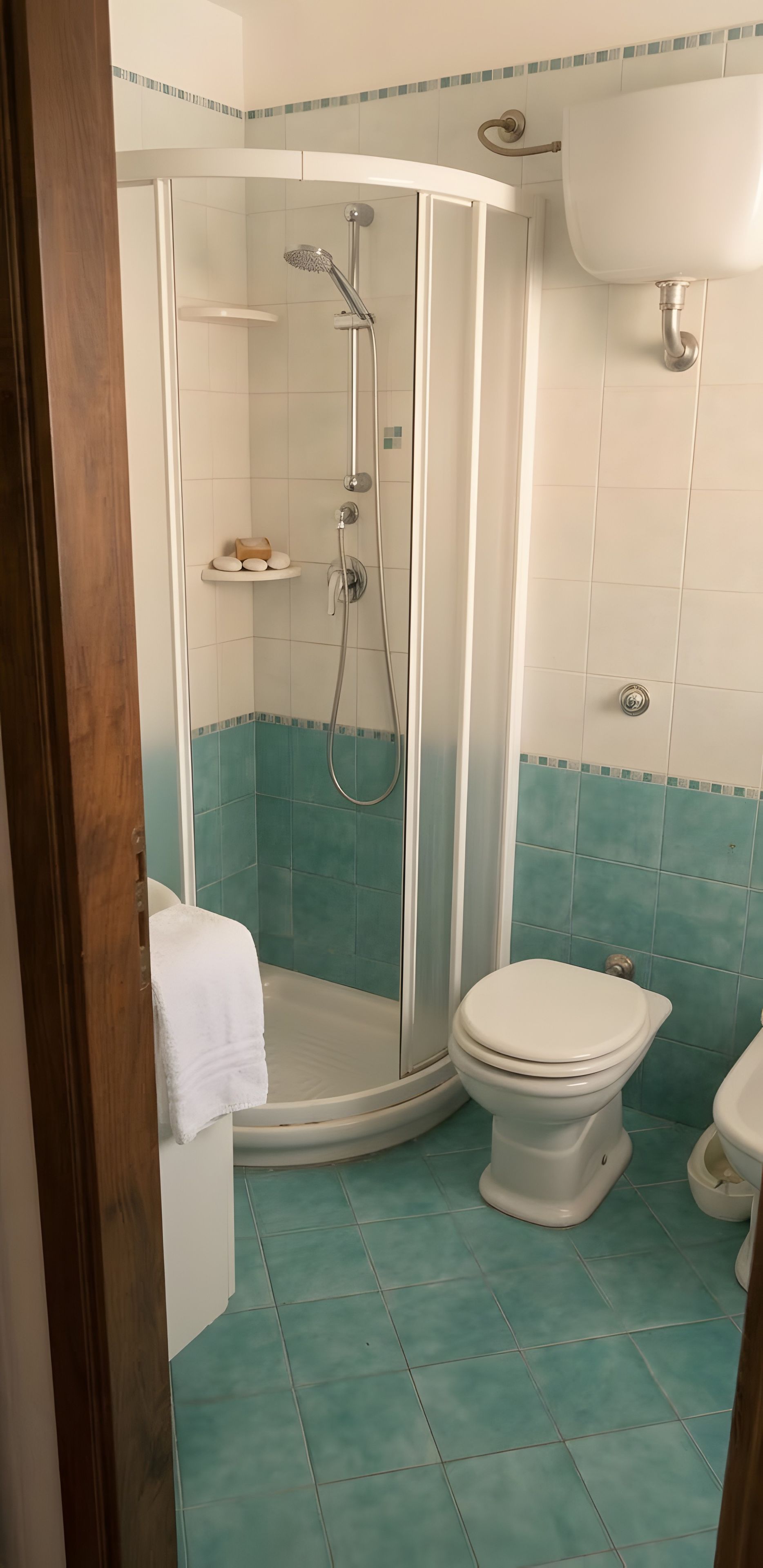 Ein Badezimmer mit Duschkabine, Toilette und Waschbecken.