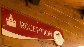 A reception sign with a logo and the word 'RECEPTION' on a wooden wall.