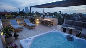 A rooftop terrace with a hot tub, lounge chairs, a dining table, and potted plants. - Casa Pedregal 301 (Cartagena de Indias)