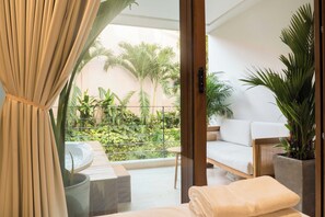 A balcony with a sofa, a hot tub, and potted plants. - Casa Pedregal (Cartagena de Indias)