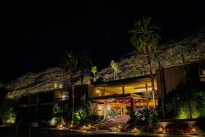 A modern hotel with a prominent entrance, multiple floors, and a landscaped garden with palm trees. - Palm Springs Tennis Club (Palm Springs)