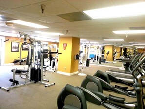 A gym with treadmills, weight machines, and a fan. - Palm Springs Tennis Club (Palm Springs)