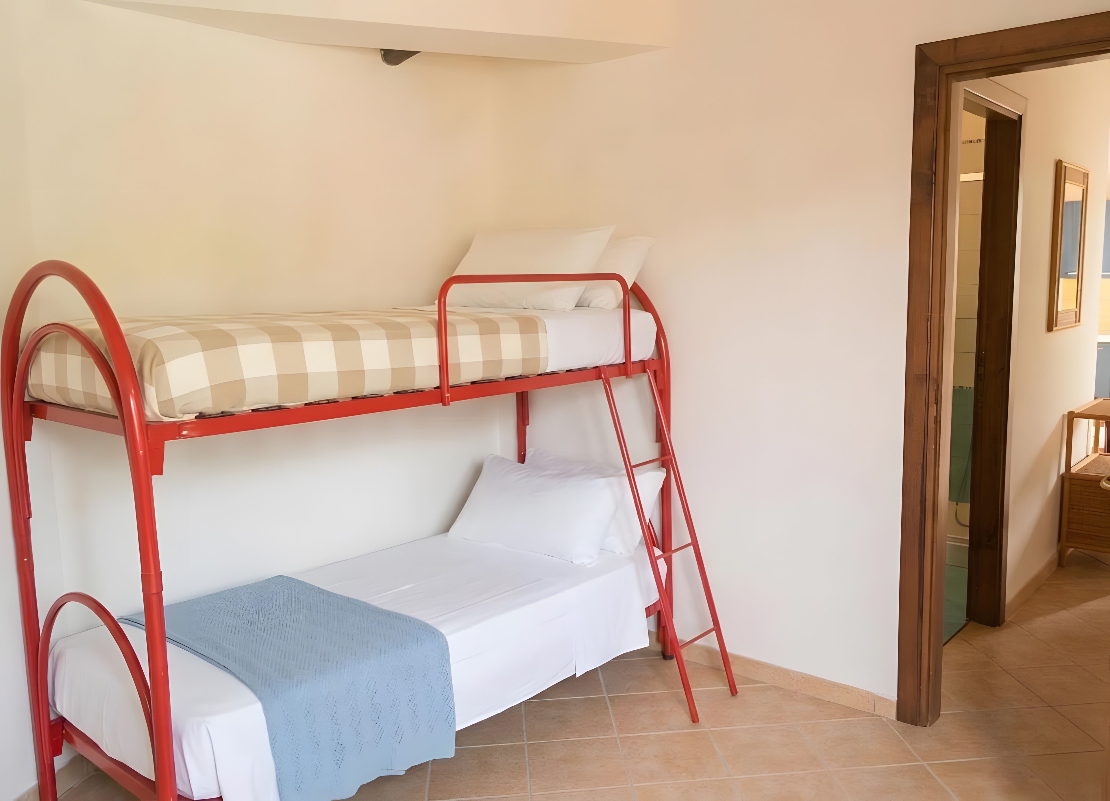 Una cama litera con un colchón superior a cuadros y un colchón inferior liso.