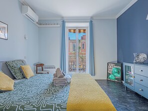 A bedroom with a bed, a chair, a dresser, and a view of the outside. - 3 chambres & terrasse - Aux portes de Monaco (Beausoleil)