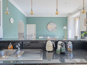 A kitchen with a sink, a kettle, a coffee maker, and a jar of snacks. - 3 chambres & terrasse - Aux portes de Monaco (Beausoleil)