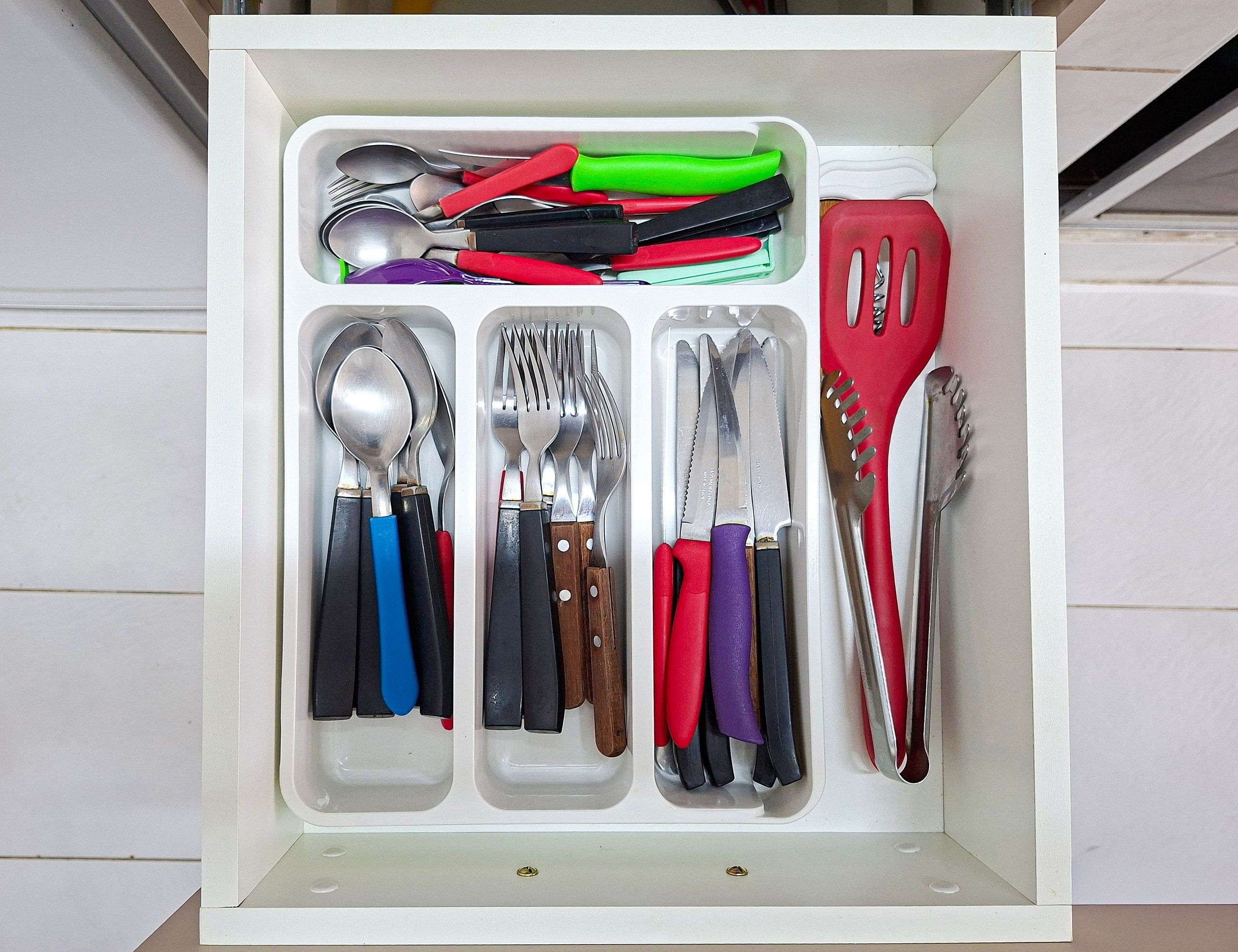 Un cajón con utensilios organizados por tipo y color.