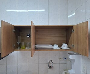 A kitchen with a wooden cabinet, a sink, and a toilet.
