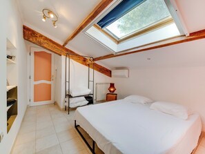 A bedroom with a skylight, a bed, a hanging chair, and a radiator. - Bail mobilité - Villa avec 4 ch, piscine & vue (La Penne-sur-Huveaune)