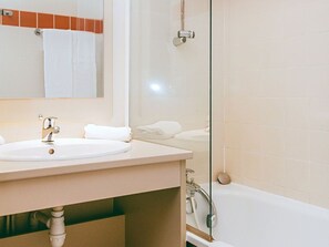 Une salle de bain avec un lavabo, un miroir et une baignoire.