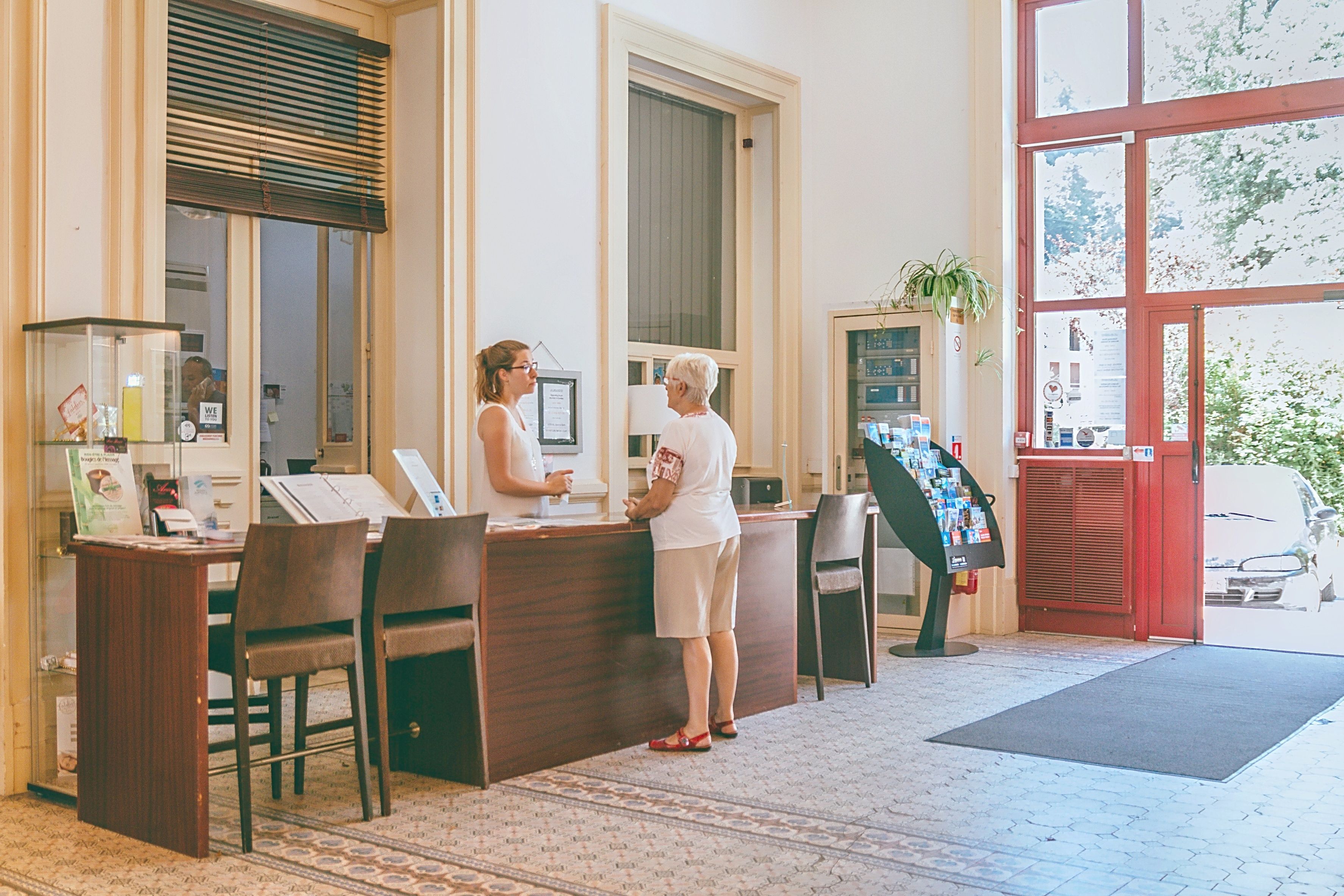 Un comptoir d’accueil avec un bureau, des chaises et une plante.