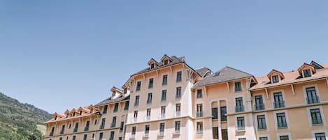 Un hôtel à plusieurs étages, caractérisé par un style architectural homogène, avec des balcons et une façade uniforme.