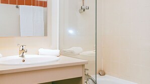 Ein Badezimmer mit Waschbecken, Spiegel und Badewanne.