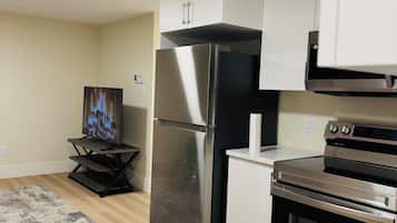 A modern kitchen with stainless steel appliances, a white countertop, and a built-in oven.