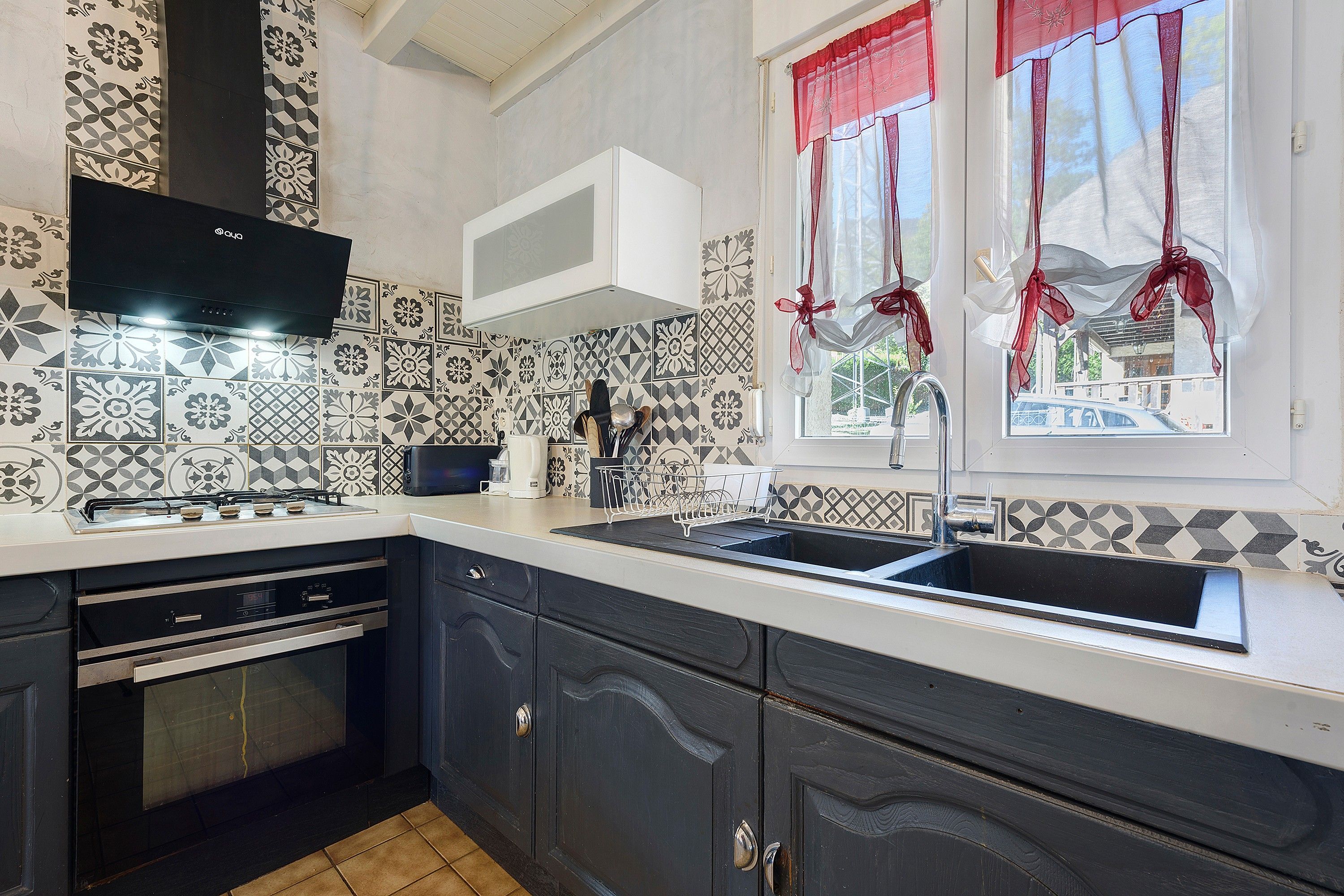 A kitchen with a gas stove, oven, and a sink.