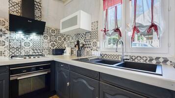 A kitchen with a gas stove, oven, and a sink.