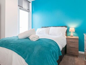 Ein Hotelzimmer mit einem Bett, einem Nachttisch und einer Lampe.