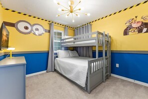 A bunk bed room with a desk and a wall decoration. - Chic Retreat in Orlando With Pool and Game Room (Clermont)