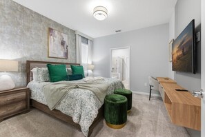 A bedroom with a bed, nightstands, a desk, and a TV. - Luxury Themed Villa With Pool and Cinema (Clermont)