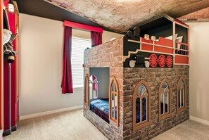 A children's playroom with a brick wall design, a bunk bed, and a window with curtains. - Luxury Themed Villa With Pool and Cinema (Clermont)