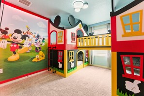 A children's play area with colorful play structures and a mural of animated characters. - Luxury Themed Villa With Pool and Cinema (Clermont)