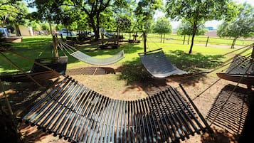 A hammock area with multiple hammocks and picnic tables in a park setting.