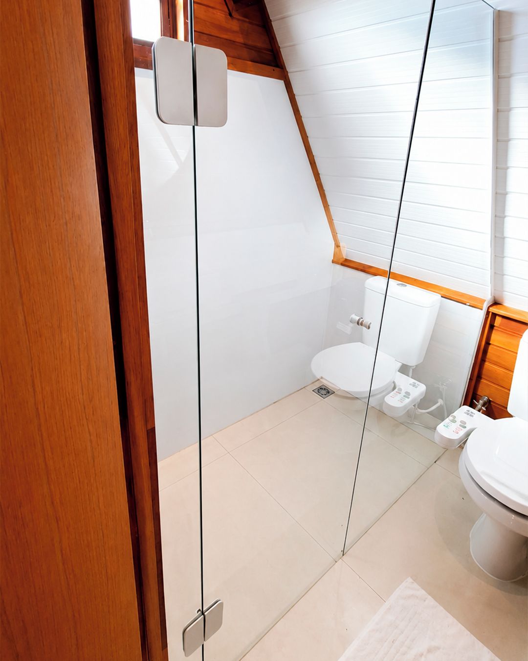 A modern bathroom with a white toilet, a bidet, and a sink.