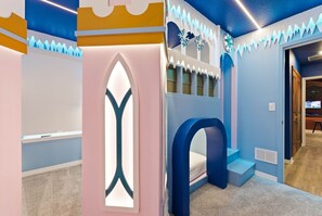 A child's playroom with a built-in slide, a window, and a door leading to another room. - Luxury Villa With 10 Bedrooms - Pool, Themed Rooms (Clermont)