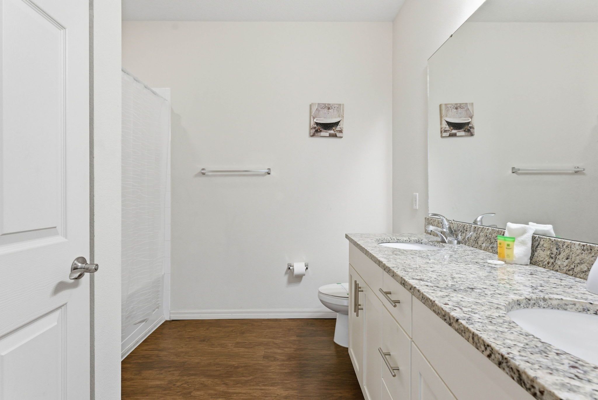 A bathroom with a toilet, a sink, and a shower area.