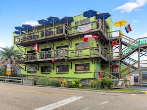 A multi-story building with outdoor seating and a staircase leading to an upper level. - BEACH TIME TOO
Incredible 3-bedroom condo  in the heart of Bay St Louis (Bay St Louis)