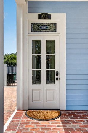 A white front door with a glass panel, a nameplate above it, and a doormat in front. - BEACH TIME TOO
Incredible 3-bedroom condo  in the heart of Bay St Louis (Bay St Louis)