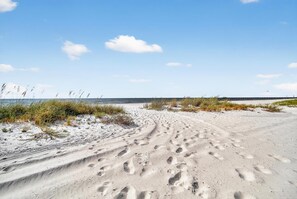 A sandy beach with footprints and sparse vegetation. - BEACH TIME TOO
Incredible 3-bedroom condo  in the heart of Bay St Louis (Bay St Louis)