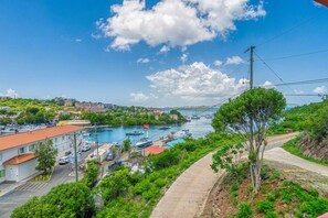 Un poble costaner amb un port esportiu, edificis i un cel serè.