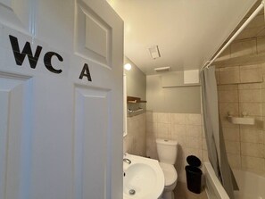 Un baño con inodoro, lavamanos y ducha.
