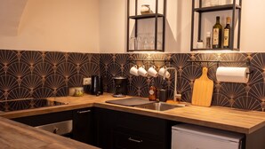 Una cocina moderna con armarios oscuros, encimera de madera y lavavajillas integrado.