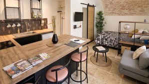 Una cocina moderna con una isla central, taburetes de bar y una mesa de comedor.