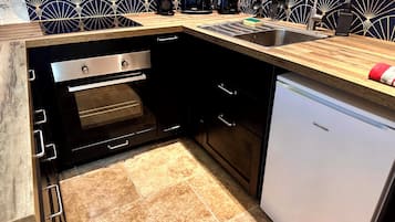 Una cocina con horno integrado, lavavajillas y fregadero.