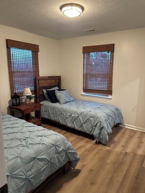 A bedroom with two beds, a nightstand, a lamp, and a ceiling light fixture. - Robin’s Nest Peaceful Kentucky Country Escape (La Grange)
