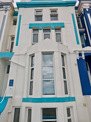 A multi-story building with a central bay window and a flat facade. - Private Beach-Front Apartment on the English Riviera with free, private parking (Paignton)