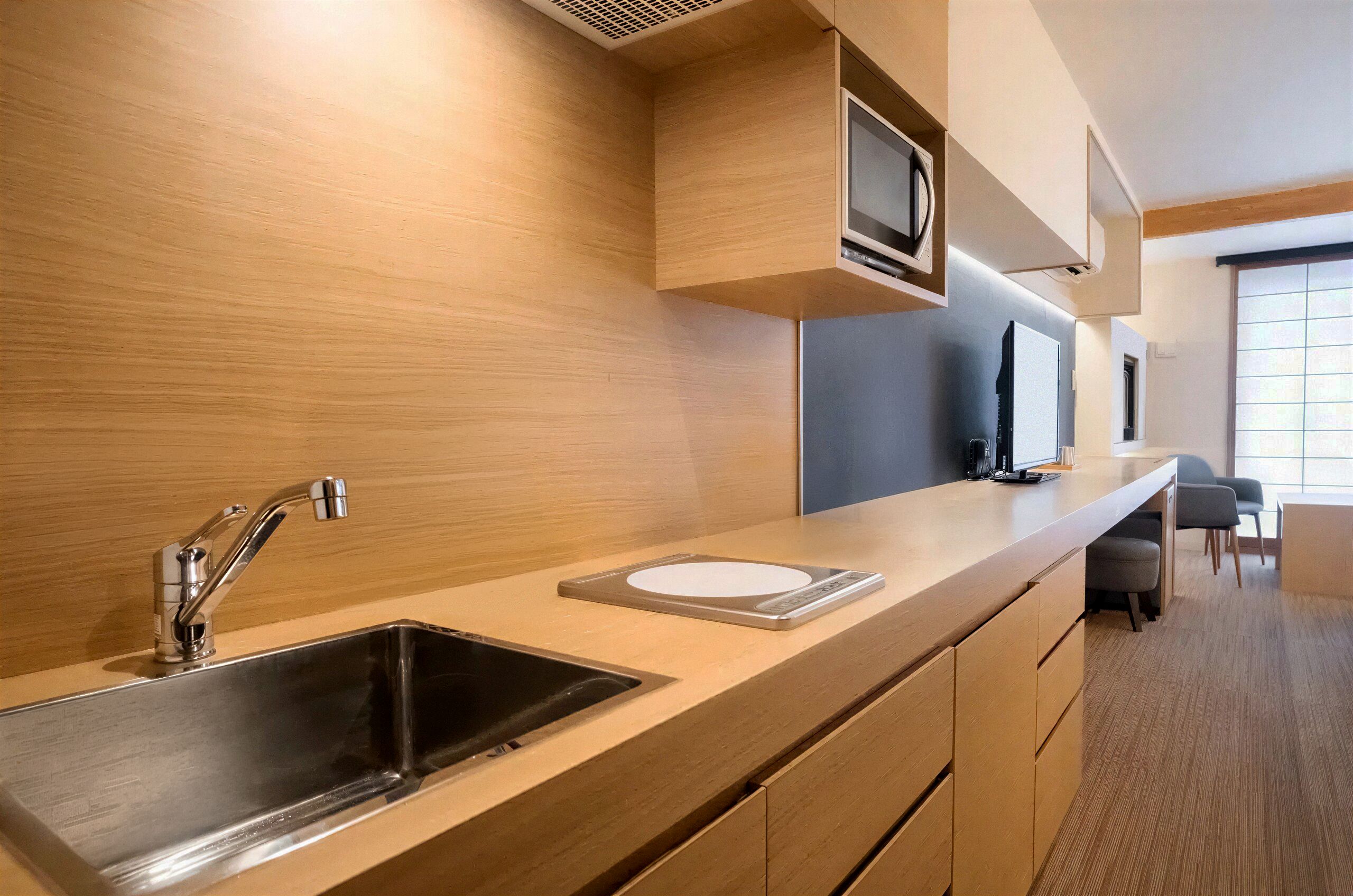 A modern kitchen with a stainless steel sink, a microwave, and a built-in oven.