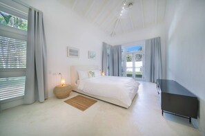 Une chambre à coucher avec un lit, une lampe de chevet et une vue sur la verdure.